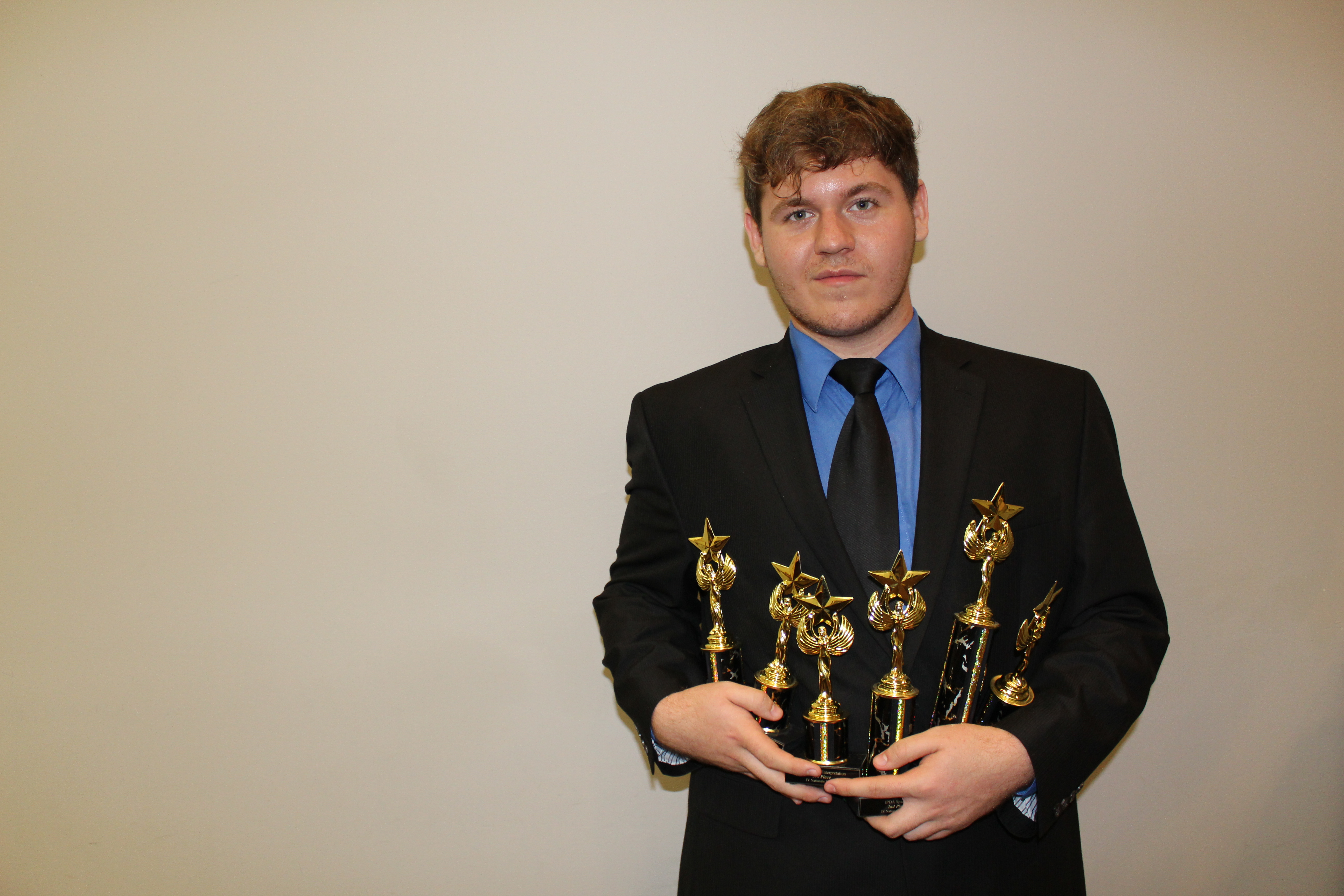 Male student holding trophies