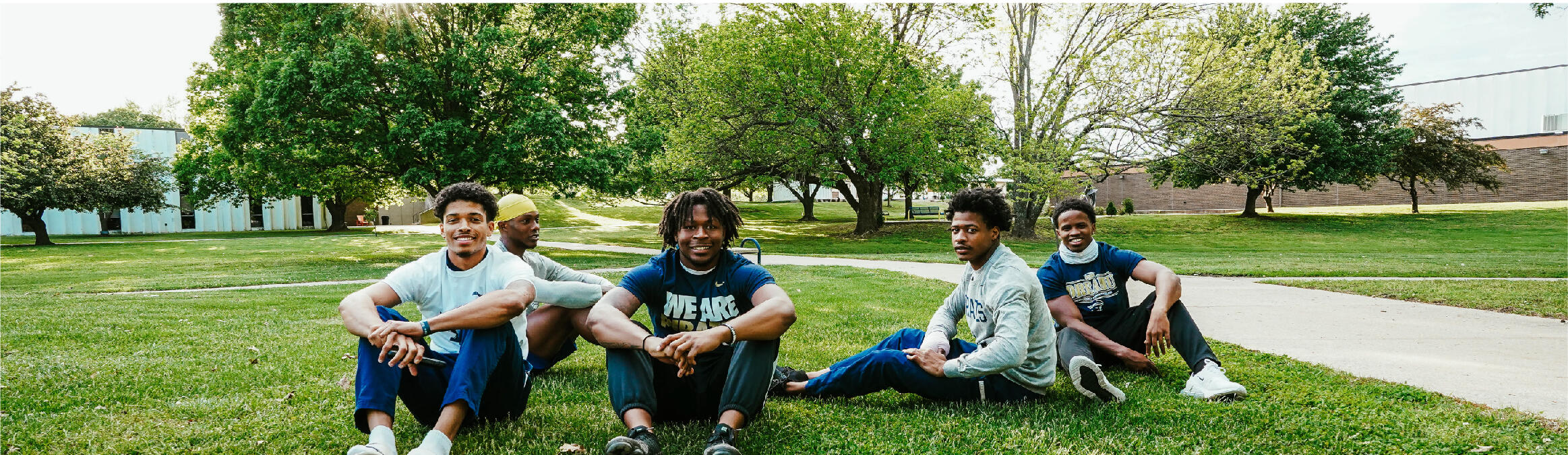 students sitting on campus lawn