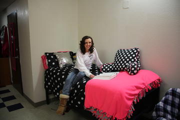 image of a young lady studying in her dorm room