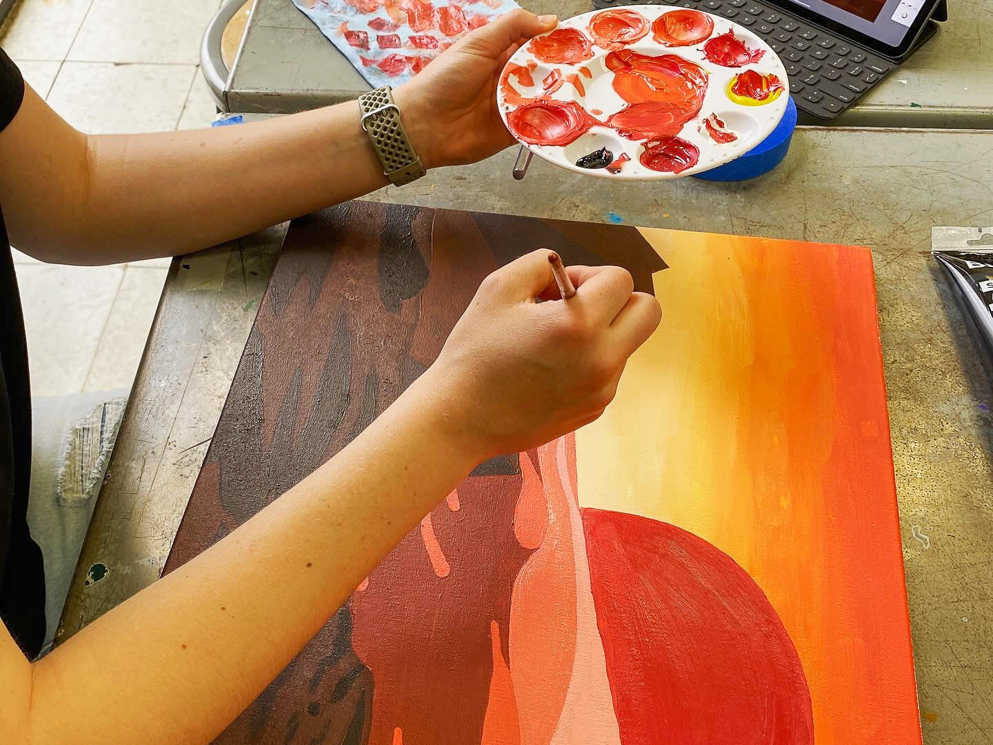 Student painting a sunset