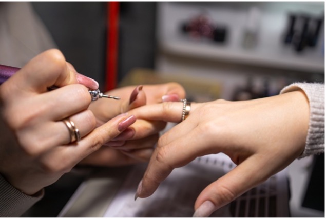 nail tech using nail drill